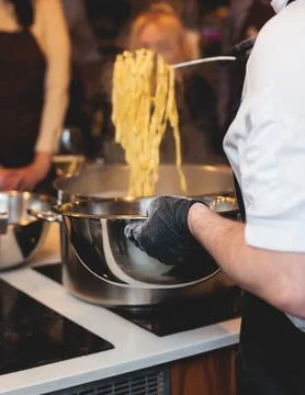 Group of guests in a cooking class studio, adults preparing different dishe.. Fotos de archivo