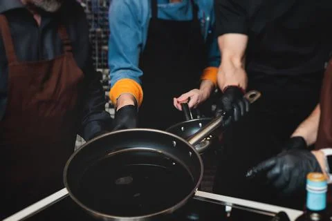 Group of guests in a cooking class studio, adults preparing different dishe.. Stock Photos