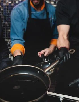 Group of guests in a cooking class studio, adults preparing different dishe.. Stock Photos