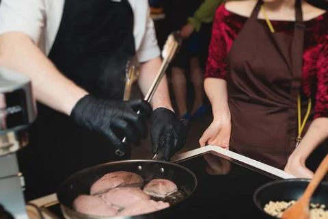 Group of guests in a cooking class studio, adults preparing different dishe.. Stock Photos
