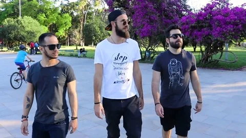 Group of Guys Walking and Looking at The Side on a Park in a Sunny Day Vídeo Stock 97027329
