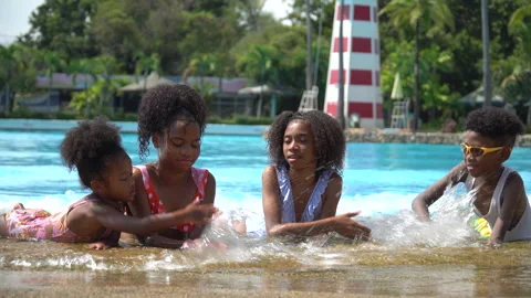 Group of happy african american kid lying on the beach at water park playing Stock Footage 145272353