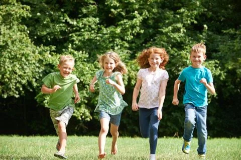Group Of Happy Children Running Towards Camera Through Field Stock Photos