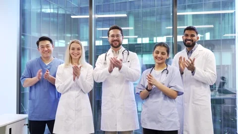 Group of happy doctors applauding look at camera standing in a hospital clinic  Stock Footage 301973725