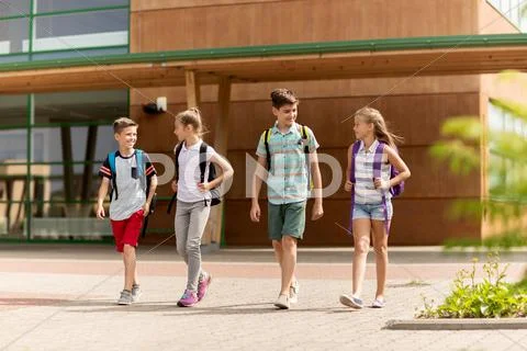 Group of happy elementary school students walking Stock Photos