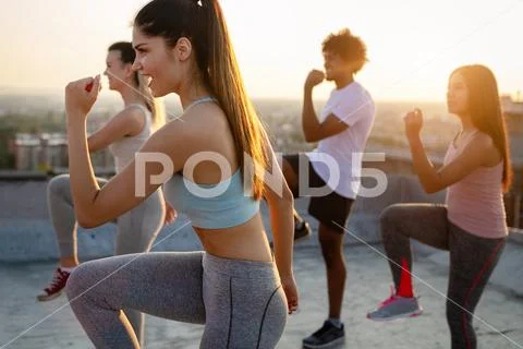 Group of happy fit friends exercising outdoor in city Stock Photos