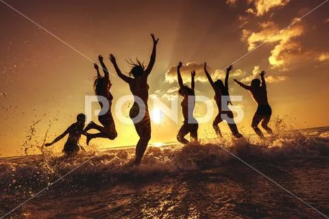 Group of happy friends fun sunset beach Stock-Fotos