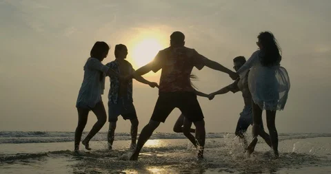 Group of happy friends guys and girls playing in water at beach party on sunset. Stock Footage 107022853