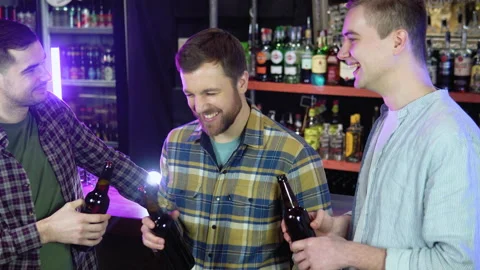 Group of happy friends having fun together, drinking bottled beer in a bar Stock Footage 231677792