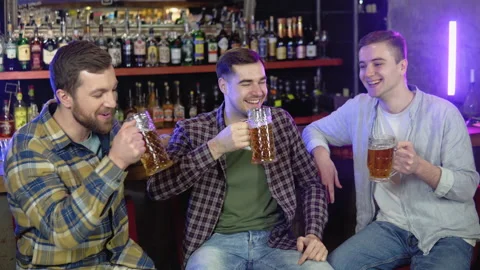 Group of happy friends having fun together, drinking beer in a bar, celebrating Stock Footage 231678281