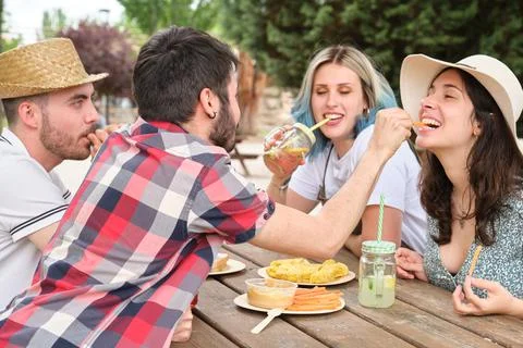 Group of happy friends having fun, drinking and eating in a park Photos