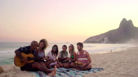 Group of happy friends playing guitar and singing on Ipanema beach Stock Footage 59378230