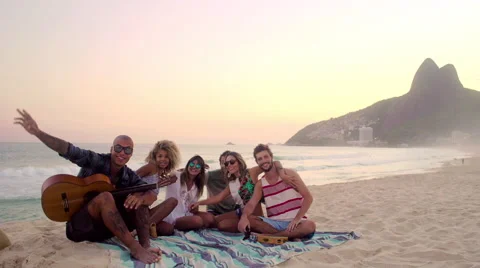 Group of happy friends posing together with guitar on Ipanema beach Stock-Footage 59378103