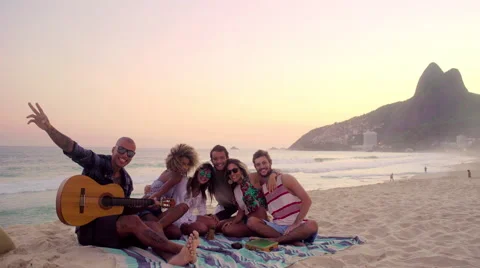 Group of happy friends posing together with guitar on Ipanema beach Stock Footage 59378313