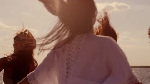 Group of happy girls running and playing in water at the beach on sunset. Beauty Stock Footage
