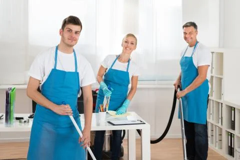 Group Of Happy Janitors Cleaning Office With Cleaning Equipments Stock Photos