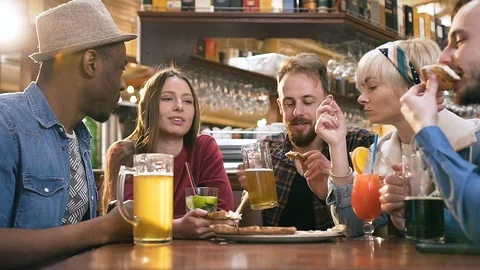 Group of happy multi ethinc friends eating pizza in the pub, bar. Stock Footage 109401311