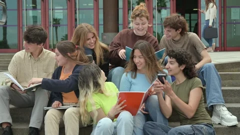 Group of happy multiethnic students reading notes near university building Stock Footage 269350034