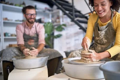 Group of happy studnets molding clay pot  on wheel  at pottery workshop. Cr.. Stock Photos