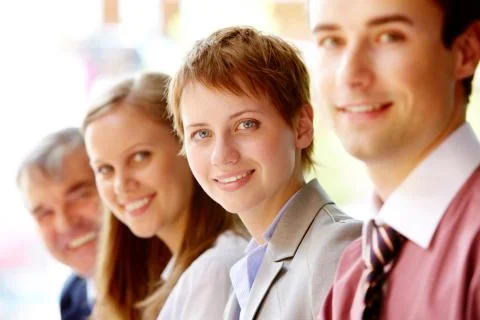Group of happy successful people in line with focus on woman Stock Photos