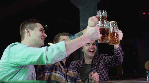 Group of happy young men drinking cold draft beer, chatting and having good time Stock Footage 231674935