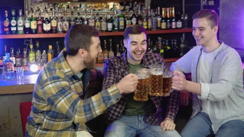Group of happy young men drinking cold draft beer, chatting and having good time Stock Footage 231676351