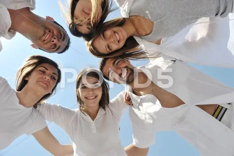 Group of happy young people in circle at beach Stock Photos