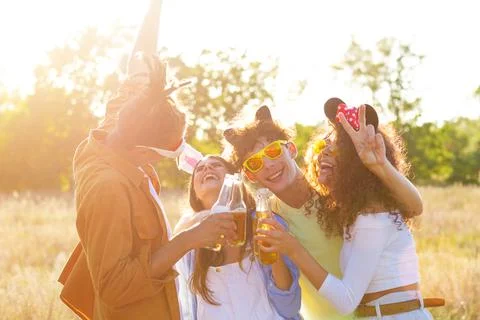Group having fun enjoying refreshing beverage. Young men and women drink beer 스톡 사진