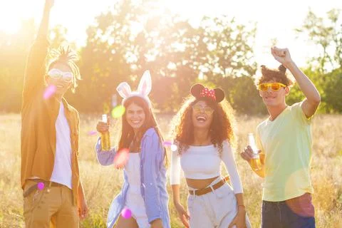 Group having fun enjoying refreshing beverage. Young men and women drink beer Stock Photos