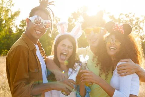 Group having fun enjoying refreshing beverage. Young men and women drink beer Stock Photos