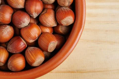 Group of hazelnuts with negative space in a clay container Stockfoto's