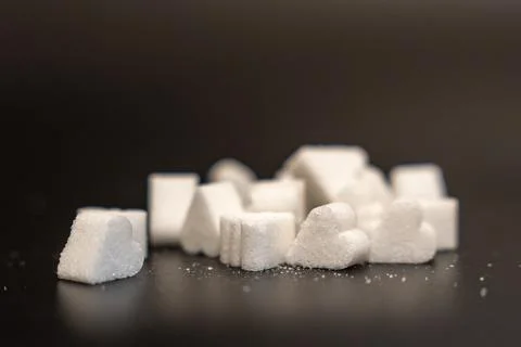 Group of heart, cube and triangle shaped sugar lumps with loose crystals Stock Photos