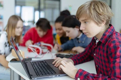 Group of high school students building and programming electric toys and robots Stock Photos
