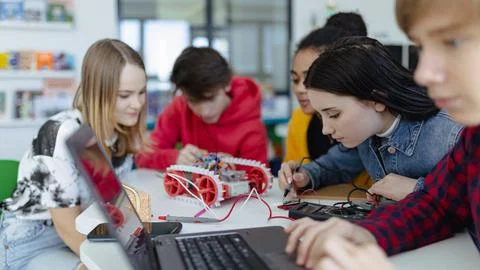 Group of high school students building and programming electric toys and robots Foto stock