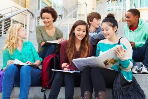 Group of high school students sitting outside building Fotos de archivo