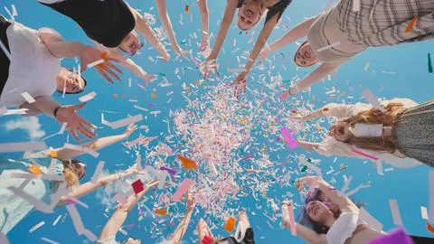 Group of high school students throwing colorful confetti in the air celebrating Stock Photos
