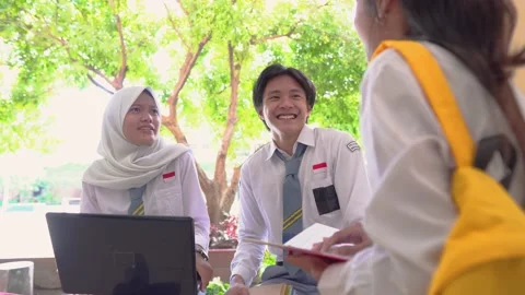 Group high school students using a laptop computer and carrying books Stock Footage 163036750