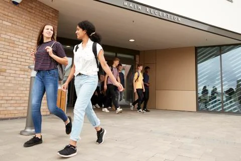 Group Of High School Students Walking Out Of College Building Together Fotos de archivo