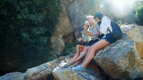 Group of hikers with backpacks use map in tablet pc to find a way in the Stock Footage 80301681