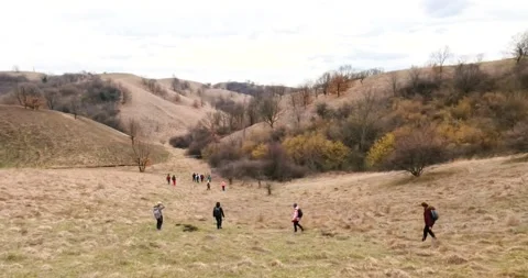 Group of Hikers Exploring a Hilly Autumn Landscape with Overcast Sky Stock Footage 304107348