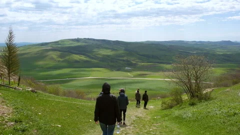 Group of hikers going down a hill to green valley. Adventure, trekking Stock Footage 262219333