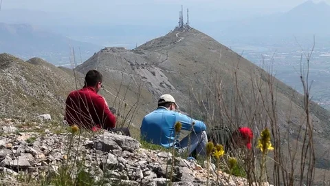 Group of hikers having a break overlooking the mountain peak Stock Footage 79793238