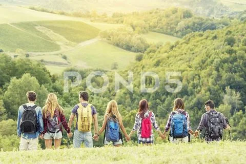 Group of hikers in the mountain in single file holding hands Stock Photos