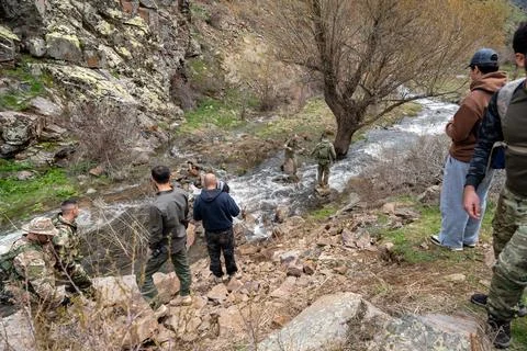 Group of hikers navigating a shallow mountain stream. 스톡 사진