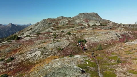 A group of hikers on a trail in the mountains, Fall colors, Drone view Stock Footage 289565663