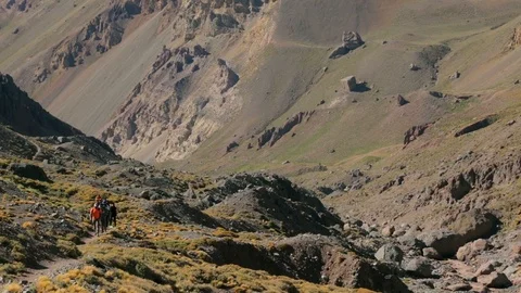 Group of hikers walk on a path through a rocky valley on Aconcagua in Argentina Stock Footage 90879467
