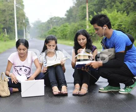 Group Of Indian College Students Studying At The Middle Of Road.