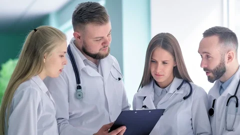 Group of interns or young doctors in white lab coat consulting with mentor or Stock-Footage 93996185