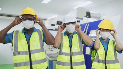 Group of interracial worker put on face mask in production factory. Stock Footage