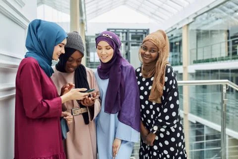 Group of islamic women of different ethnicity watching on the phone together Stock Photos